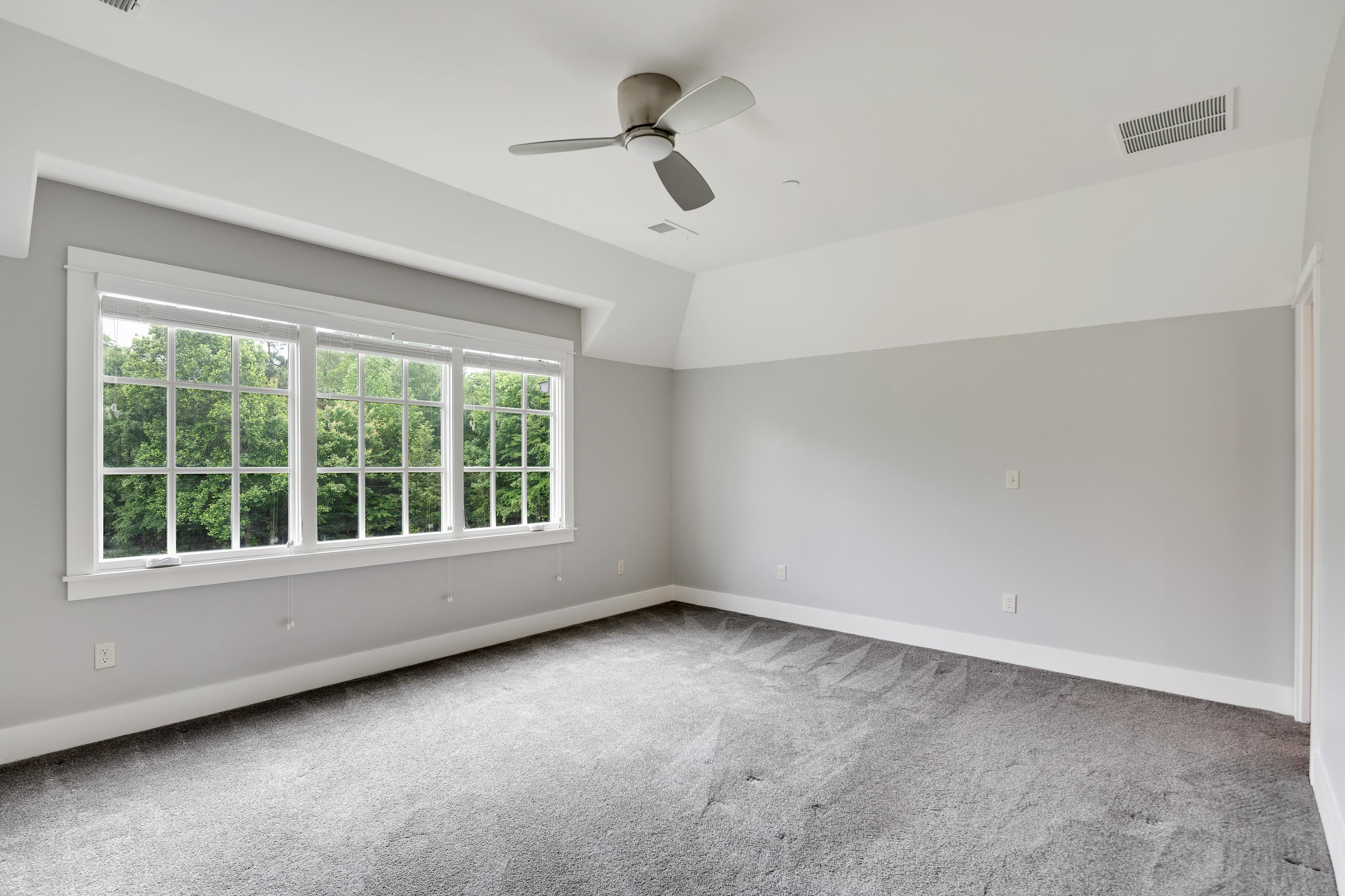 55 East Old State Line Road Piperton, TN 38017 - Photo 34 of 40 Spacious room featuring a three-panel window with grid detailing, gray carpeting, neutral wall colors, a ceiling fan, and white trim