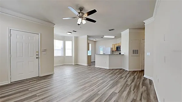 a view of an empty room with wooden floor and a window