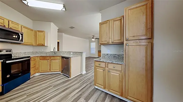 a kitchen with stainless steel appliances granite countertop a stove a sink and a refrigerator