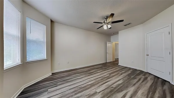 a view of empty room with wooden floor