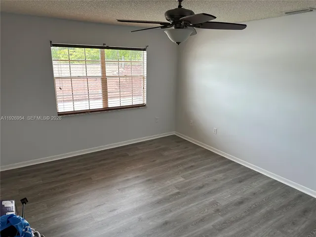 an empty room with wooden floor and white door