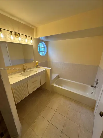 a bathroom with a granite countertop sink a toilet and bathtub