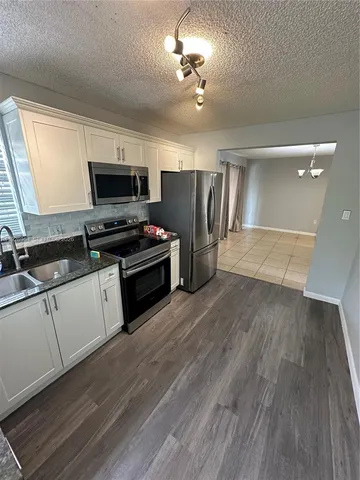 a kitchen with a refrigerator and a stove top oven