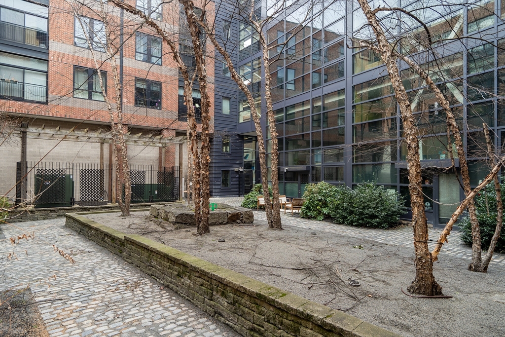 251 Heath Street, Unit 421 Boston, MA 02130 - Photo 17 of 20 a view of a brick building next to a yard
