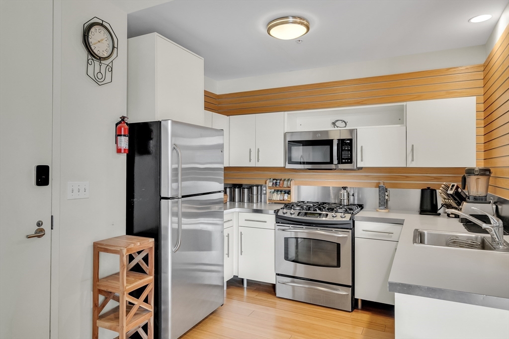 251 Heath Street, Unit 421 Boston, MA 02130 - Photo 3 of 20 a kitchen with stainless steel appliances a stove a microwave and a refrigerator