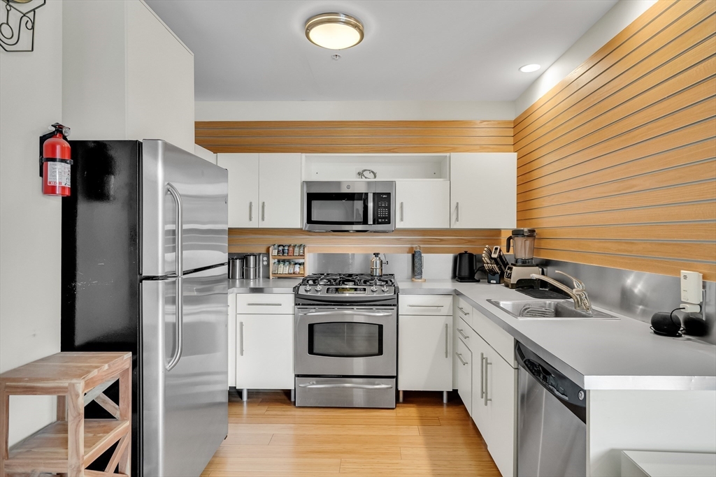 251 Heath Street, Unit 421 Boston, MA 02130 - Photo 4 of 20 a kitchen with a sink a stove and refrigerator