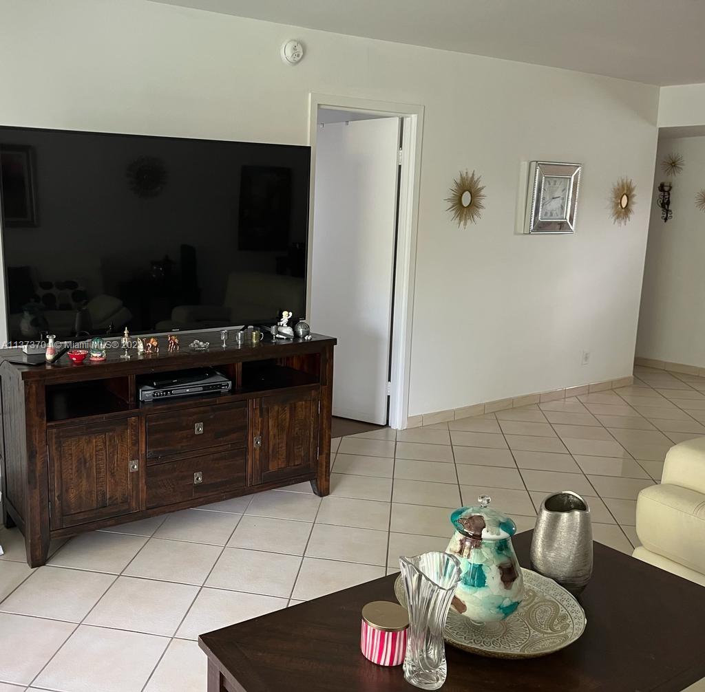 8340 Sands Point Boulevard, Unit P309 Tamarac, FL 33321 - Photo 12 of 33 a living room with furniture and a flat screen tv
