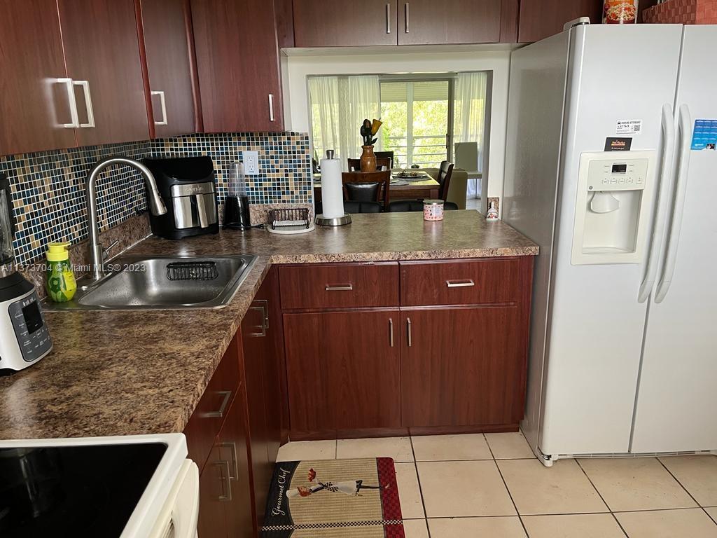 8340 Sands Point Boulevard, Unit P309 Tamarac, FL 33321 - Photo 26 of 33 a kitchen with granite countertop a refrigerator a stove a sink and dishwasher