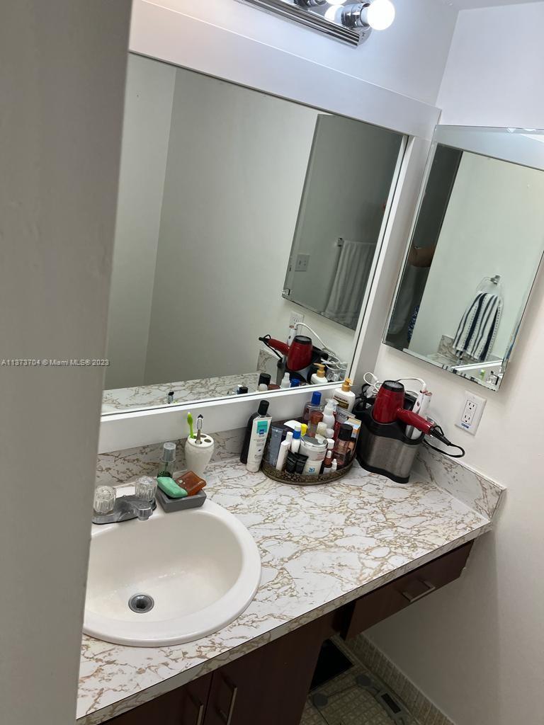 8340 Sands Point Boulevard, Unit P309 Tamarac, FL 33321 - Photo 28 of 33 a bathroom with a sink and a mirror