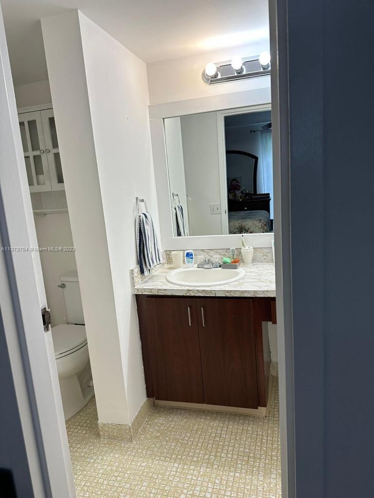 8340 Sands Point Boulevard, Unit P309 Tamarac, FL 33321 - Photo 7 of 33 a bathroom with a sink a mirror and vanity