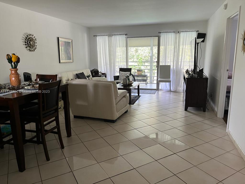 8340 Sands Point Boulevard, Unit P309 Tamarac, FL 33321 - Photo 10 of 33 a living room with furniture a flat screen tv and a window