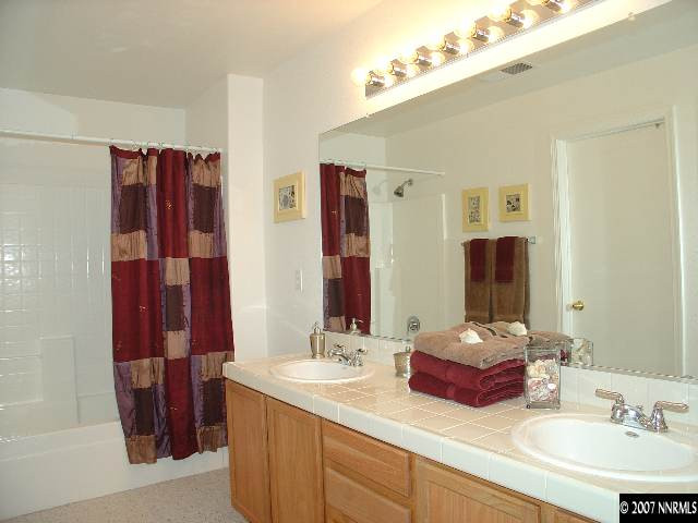 7765 Welsh Drive Reno, NV 89506 - Photo 9 of 9 a bathroom with a double vanity sink and a mirror