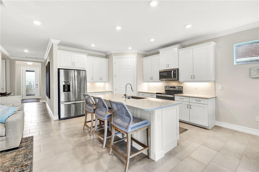 267 Tamarindo Lane Naples, FL 34114 - Photo 10 of 45 a kitchen with a refrigerator and a stove top oven