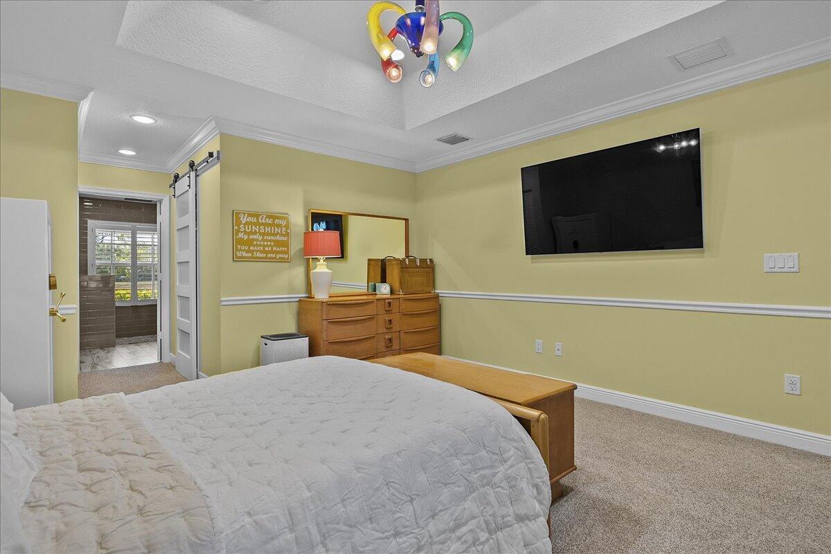 10975 Randolph Siding Road Jupiter, FL 33478 - Photo 36 of 97 a bedroom with a bed and a flat screen tv