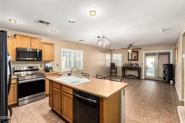 a kitchen with stainless steel appliances granite countertop a sink dishwasher stove and refrigerator