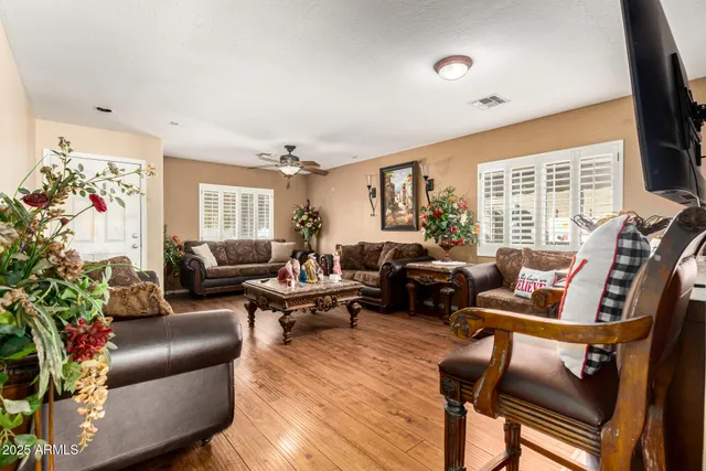 a living room with furniture flat screen tv and a large window