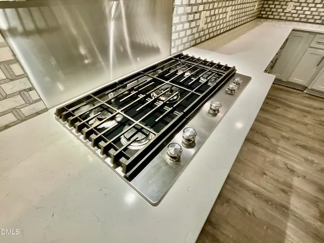 a kitchen with kitchen island granite countertop a sink a center island stainless steel appliances and cabinets