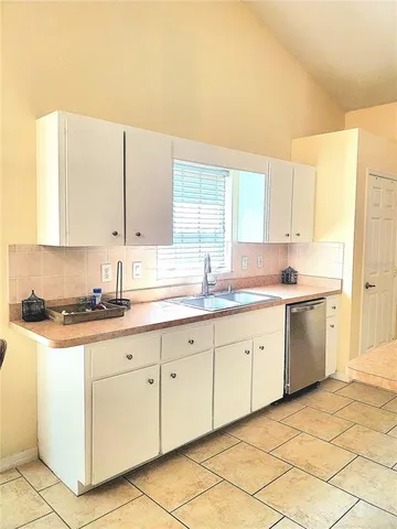 a kitchen with stainless steel appliances granite countertop a refrigerator a stove top oven and a sink