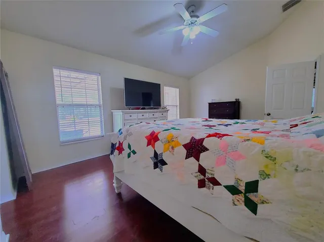 a bedroom with a bed and wooden floor
