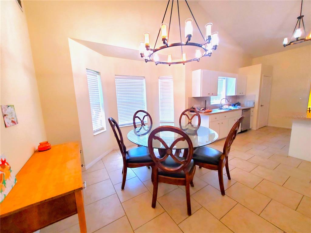 13599 Southeast 51st Terrace Summerfield, FL 34491 - Photo 29 of 44 a dining room with furniture and a chandelier