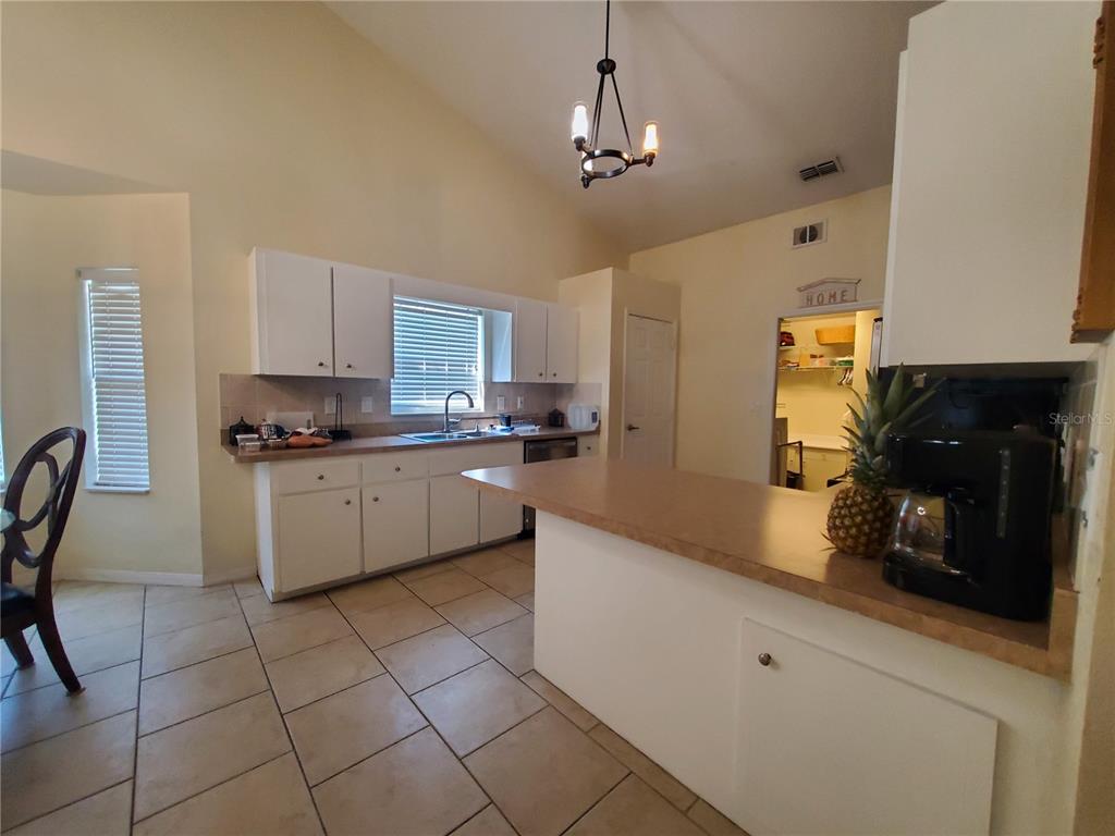 13599 Southeast 51st Terrace Summerfield, FL 34491 - Photo 30 of 44 a kitchen with stainless steel appliances granite countertop a sink a stove a refrigerator cabinets and chairs