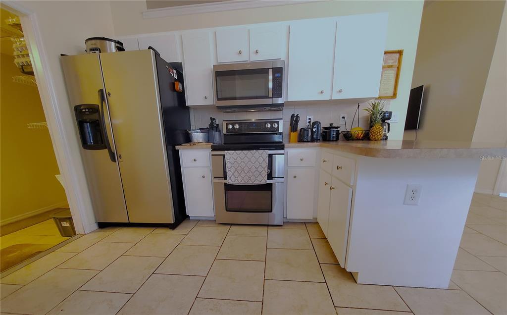 13599 Southeast 51st Terrace Summerfield, FL 34491 - Photo 31 of 44 a kitchen with a refrigerator sink and cabinets