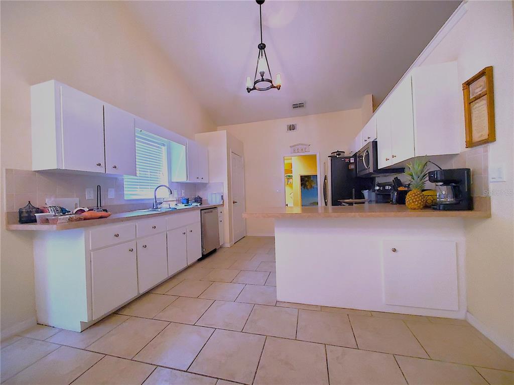 13599 Southeast 51st Terrace Summerfield, FL 34491 - Photo 32 of 44 a kitchen with a sink window and cabinets