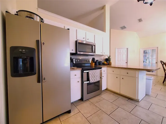 a kitchen with granite countertop a stove a sink and a refrigerator