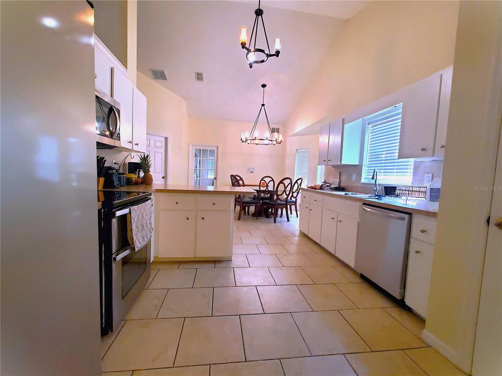 13599 Southeast 51st Terrace Summerfield, FL 34491 - Photo 34 of 44 a kitchen with granite countertop a stove a sink and a refrigerator