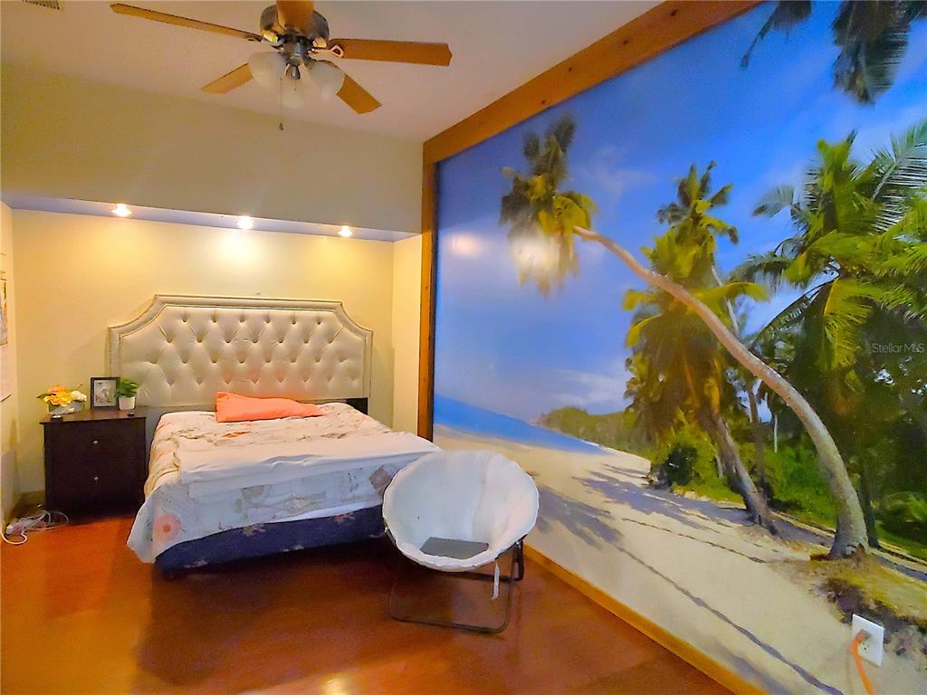 13599 Southeast 51st Terrace Summerfield, FL 34491 - Photo 36 of 44 a bedroom with a bed and a painting on the wall