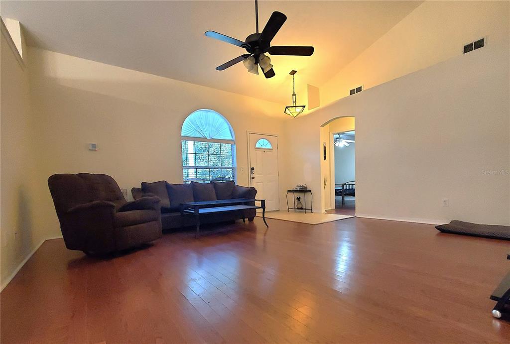 13599 Southeast 51st Terrace Summerfield, FL 34491 - Photo 9 of 44 a living room with furniture and a chandelier