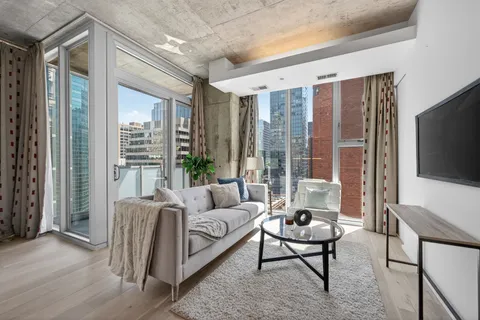a living room with furniture a flat screen tv and a large window