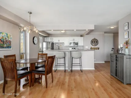 a kitchen with stainless steel appliances granite countertop a kitchen island a stove a table and chairs in it