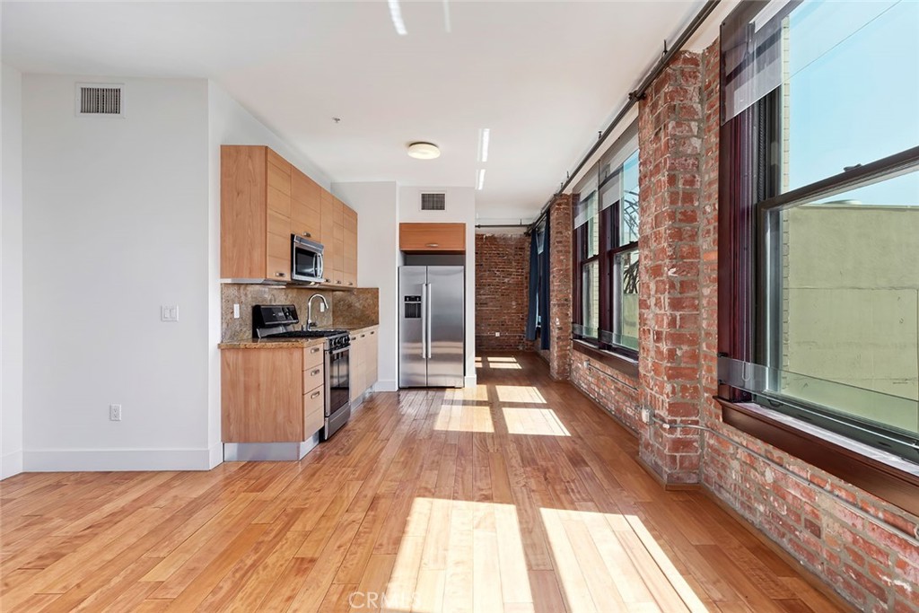 460 South Spring Street, Unit 802 Los Angeles, CA 90013 - Photo 12 of 25 a kitchen with stainless steel appliances a refrigerator and a stove top oven