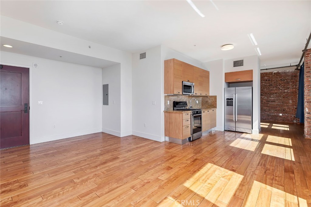 460 South Spring Street, Unit 802 Los Angeles, CA 90013 - Photo 14 of 25 a kitchen with granite countertop a refrigerator and a stove top oven