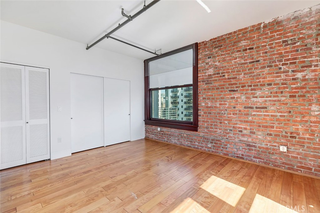 460 South Spring Street, Unit 802 Los Angeles, CA 90013 - Photo 19 of 25 a view of an empty room with a window and wooden floor