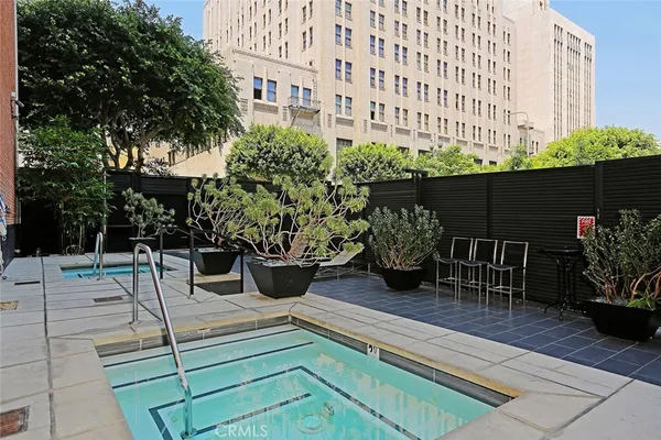 a view of a patio with table and chairs potted plants and large tree