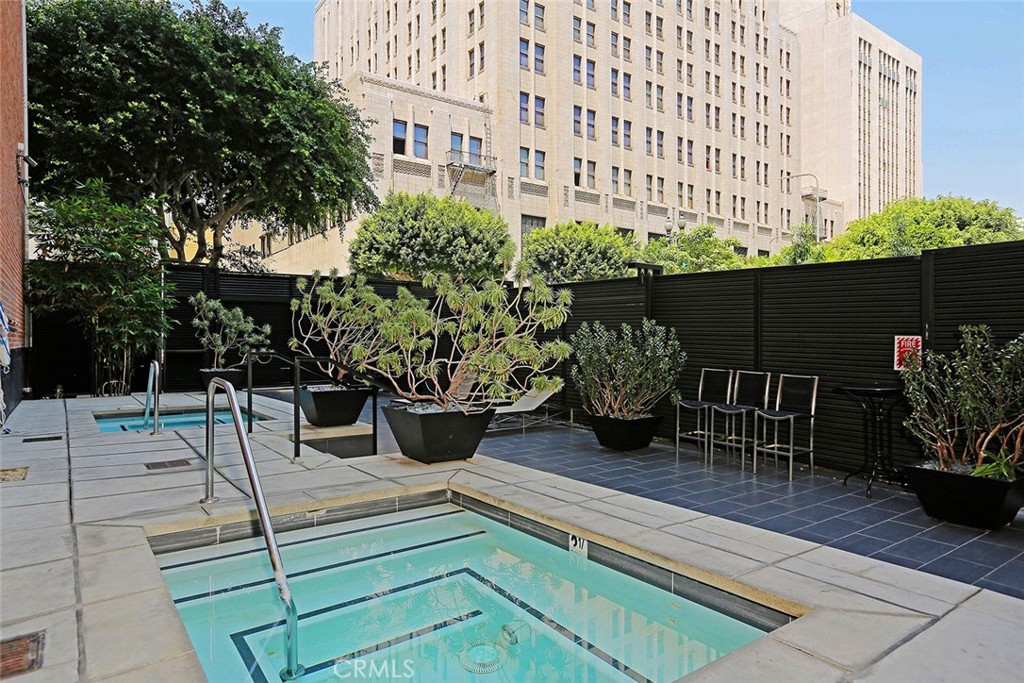 460 South Spring Street, Unit 802 Los Angeles, CA 90013 - Photo 5 of 25 a view of a patio with table and chairs potted plants and large tree