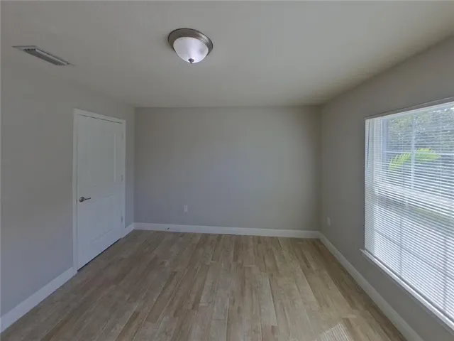 a view of a room with wooden floor and window