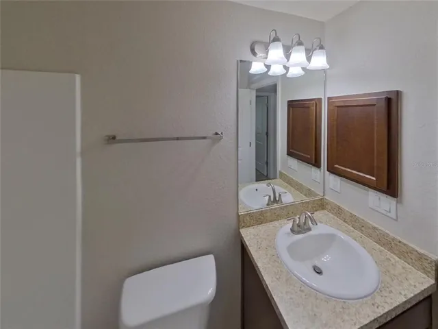 a bathroom with a sink toilet and mirror