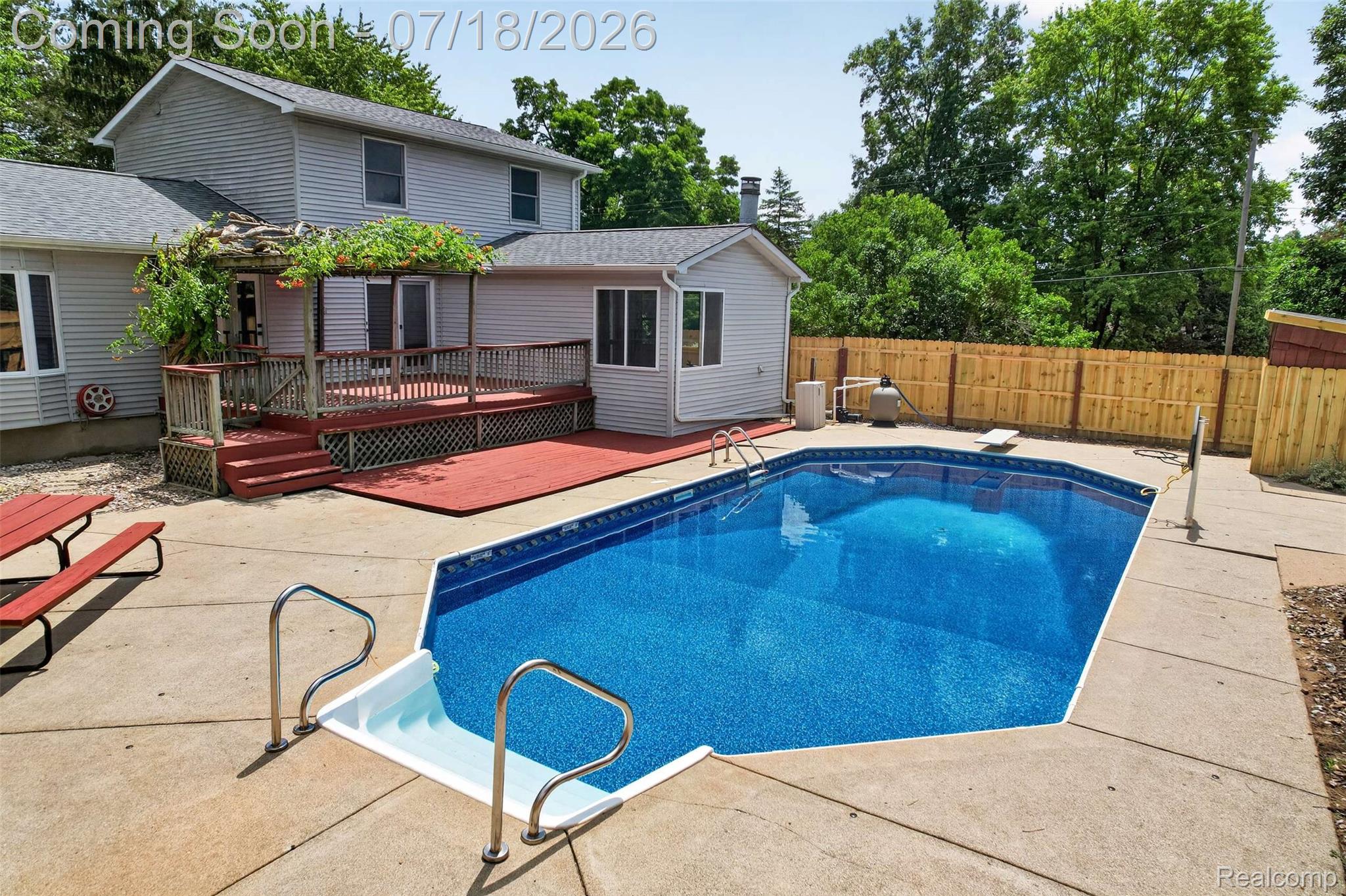 1437 East Cook Road Grand Blanc, MI 48439 - Photo 11 of 69 Expansive backyard featuring an in-ground swimming pool with concrete decking, a multi-level wood deck, and a privacy fence
