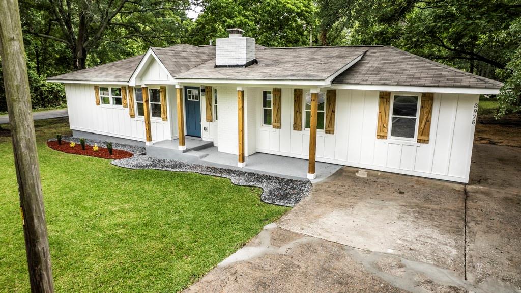a front view of a house with a yard and trees