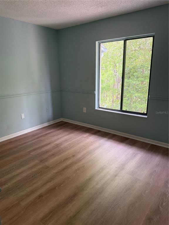 1236 Pine Ridge Circle West, Unit G3 Tarpon Springs, FL 34688 - Photo 15 of 18 an empty room with wooden floor and windows