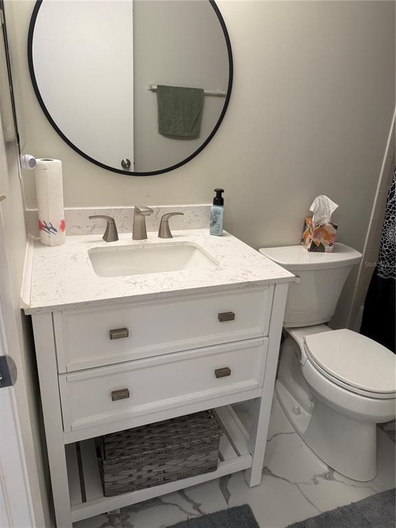 1236 Pine Ridge Circle West, Unit G3 Tarpon Springs, FL 34688 - Photo 17 of 18 a bathroom with a sink mirror and toilet