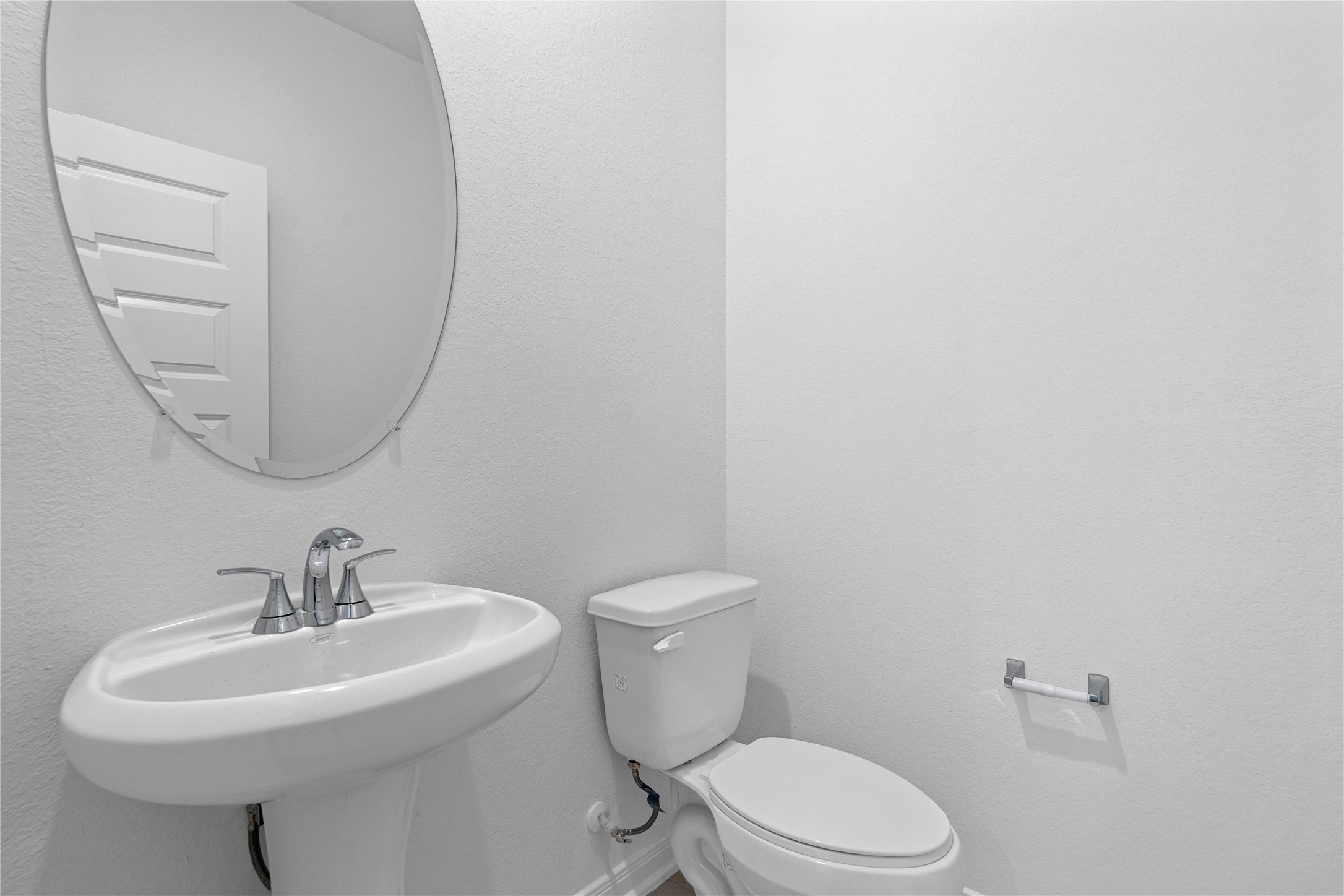 25503 Alpine Switchback Drive Spring, TX 77373 - Photo 7 of 32 The powder bathroom features engineered wood flooring, custom paint, pedestal sink with Moen faucet, and oval mirror.