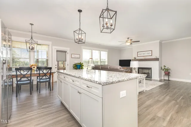 a kitchen with stainless steel appliances granite countertop cabinets a stove top oven a dining table and chairs