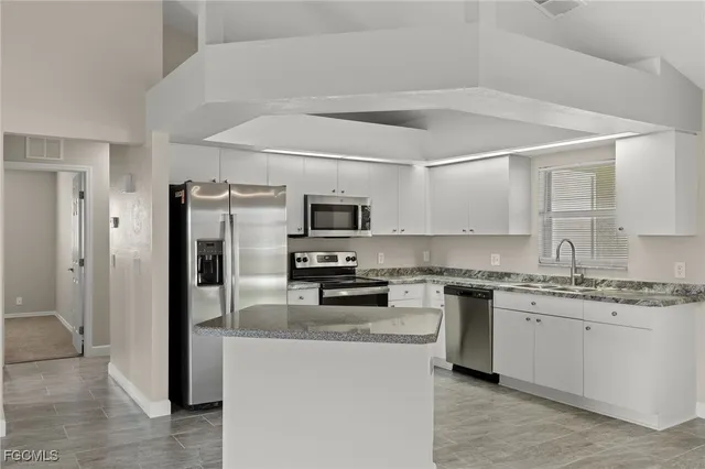 a kitchen with stainless steel appliances granite countertop a refrigerator stove and sink