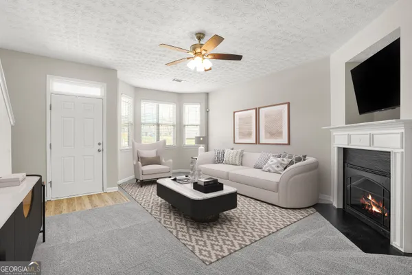 a living room with furniture a flat screen tv and a fireplace