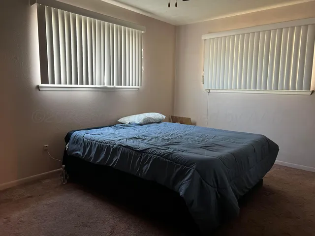 a bedroom with a bed next to a window
