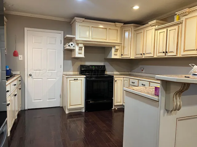a kitchen with stainless steel appliances granite countertop a refrigerator and a stove top oven